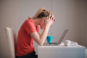 Girl with head in her hands at computer