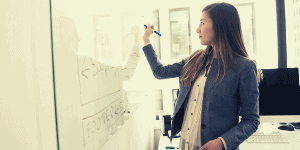 Professional woman writing on white board