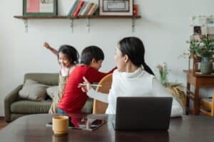 Mom working at home with kids in background