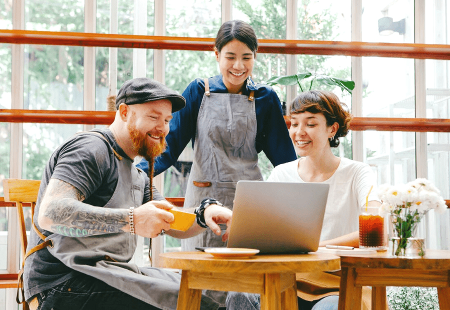 Header image of three people working at table on laptop