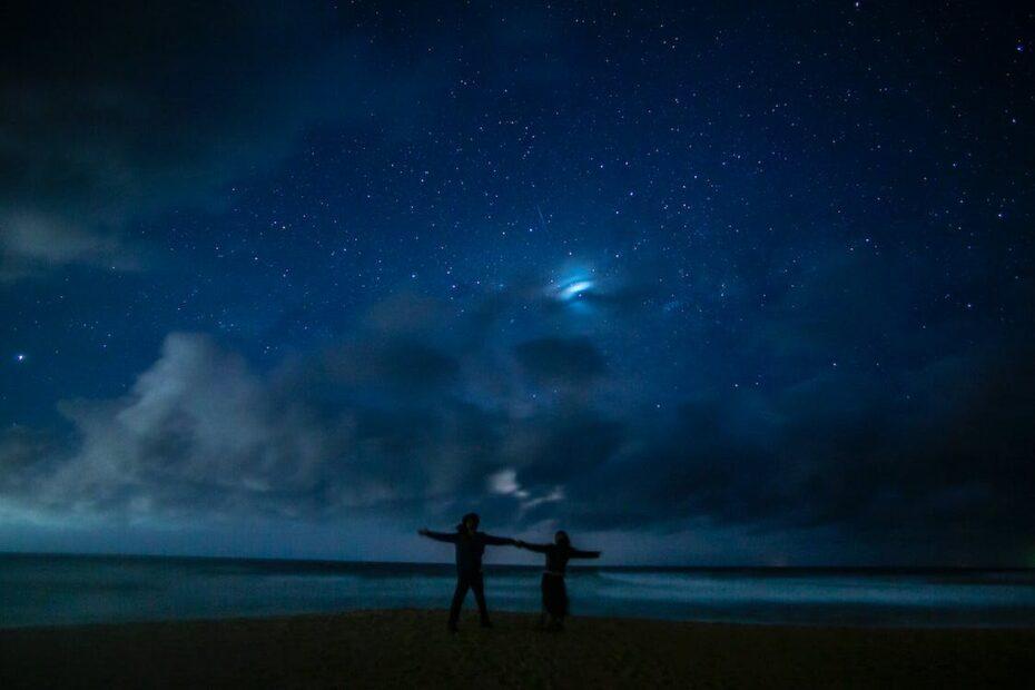 Couple on the beach at night with stars in the sky